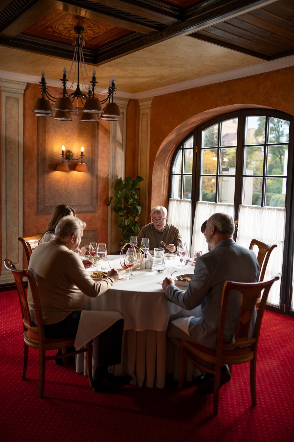 Gezelschap in gesprek rond een gedekte tafel in een klassieke eetkamer